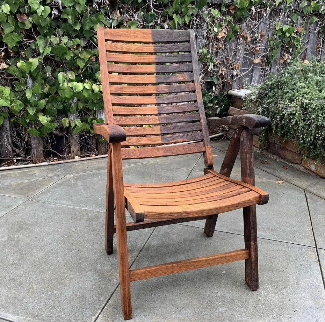 Outdoor wood chair pressure washed exactly half, grimy on one side and clean on the other